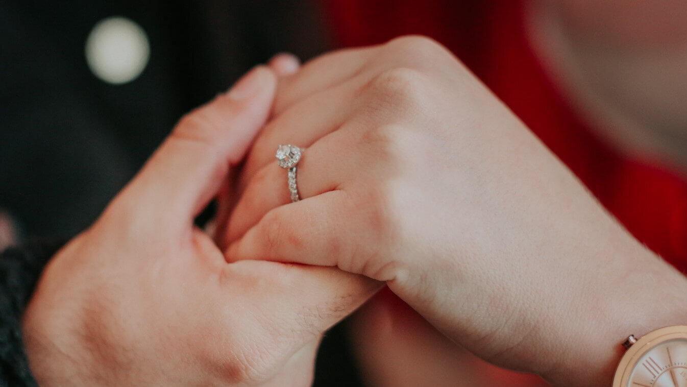 guy placing engagement ring on the correct left-hand ring finger