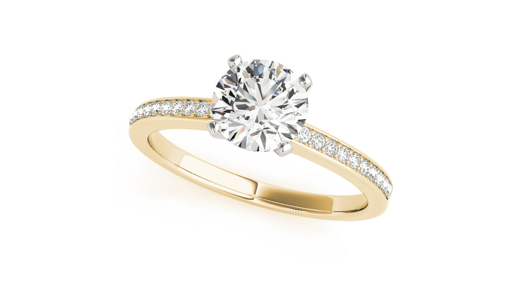 The image shows a classic solitaire pave diamond engagement ring with a round cut diamond set in a yellow gold band. The main diamond is prominently displayed in a prong setting. The band is partially lined with smaller round diamonds, adding extra sparkle and elegance to the overall design. 