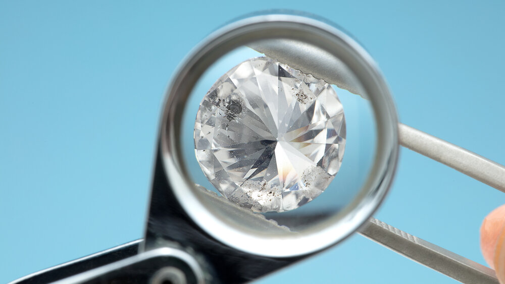 Checking I1 diamond clarity under magnification, showing visible inclusions from the back side of a diamond